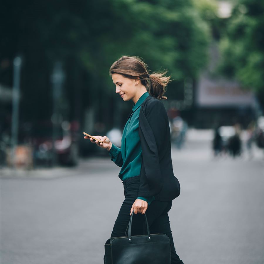 vrouw loopt op straat met telefoon