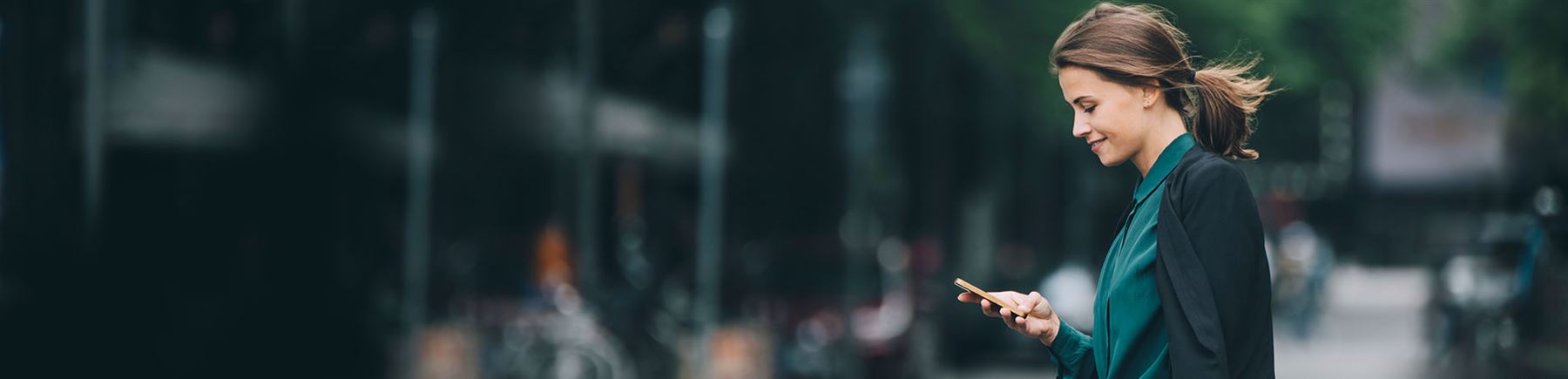 vrouw loopt op straat met telefoon