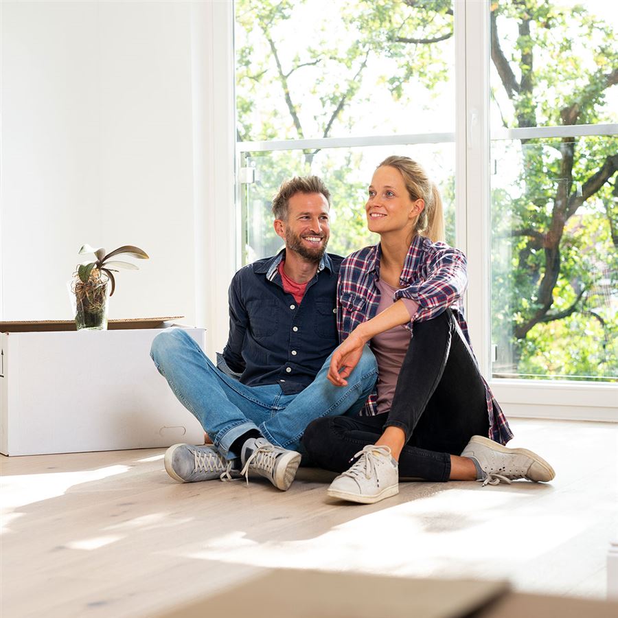 koppel zit op de vloer van hun nieuwe huis