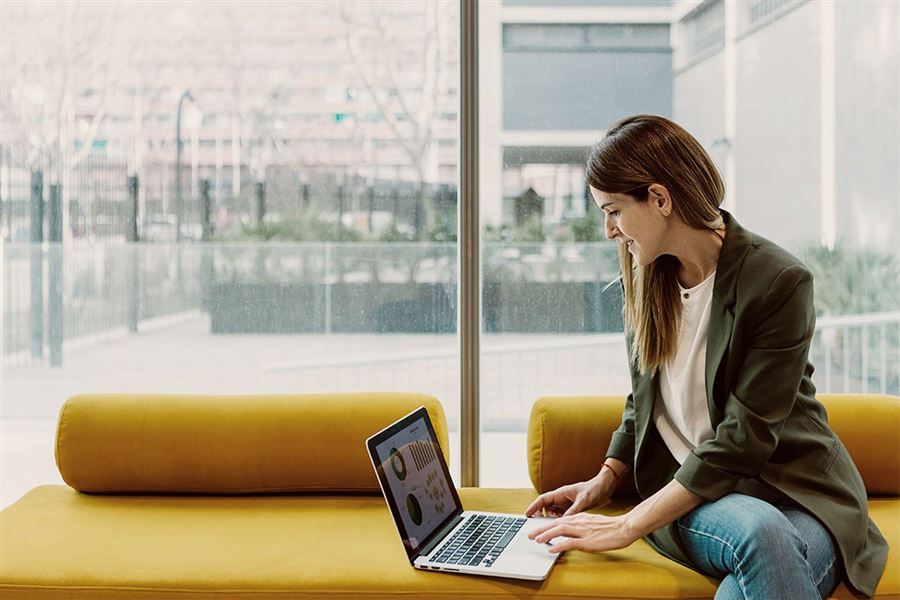 vrouw zit op bank met laptop
