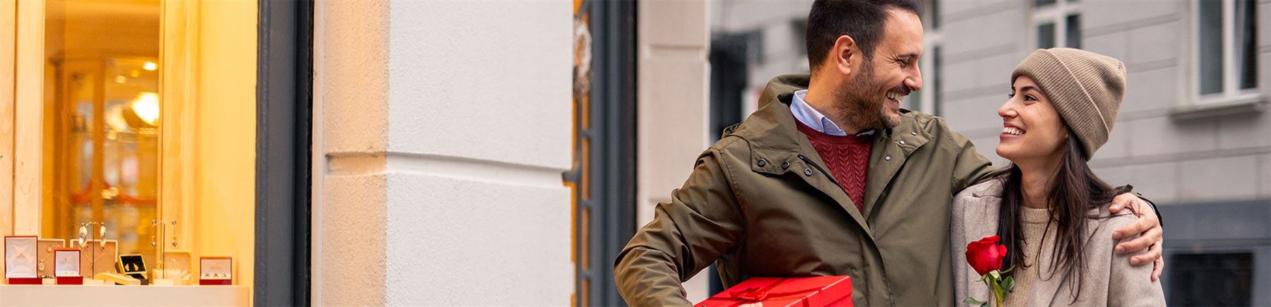 Koppel loopt met rode roos op straat