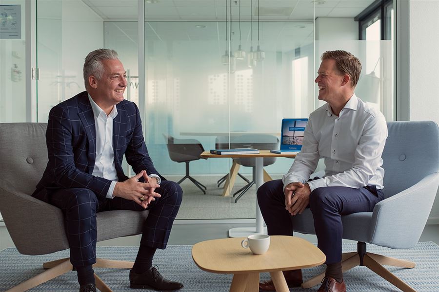 Twee collega's in gesprek op kantoor in amsterdam