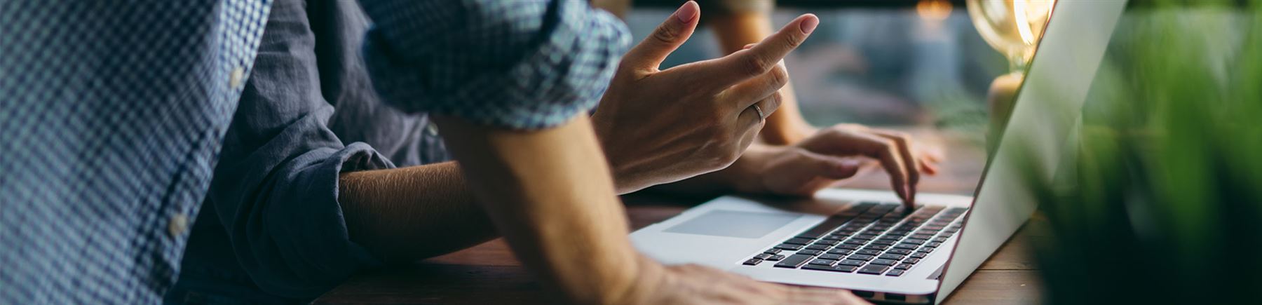 Twee collega's kijken op scherm van laptop