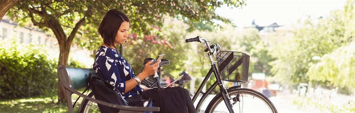 lady on a bench looking at her telephone